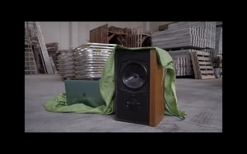 A speaker wrapped in green fabric in an industrial space