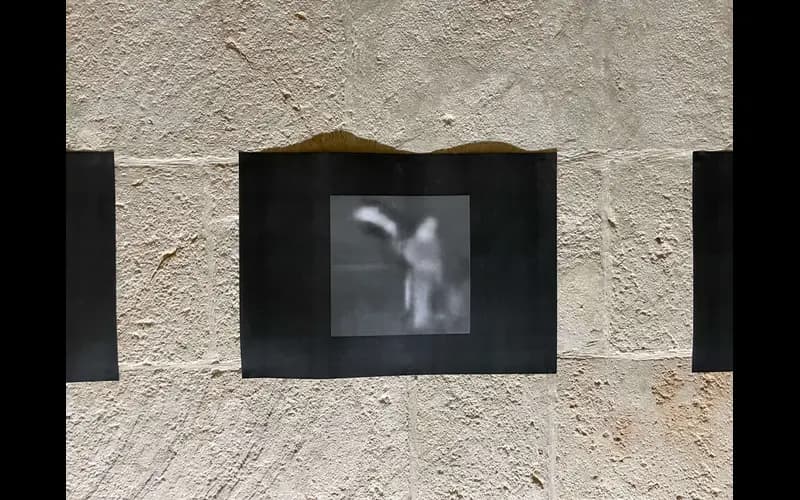 Small screen showing a blurred monochrome image on a textured wall