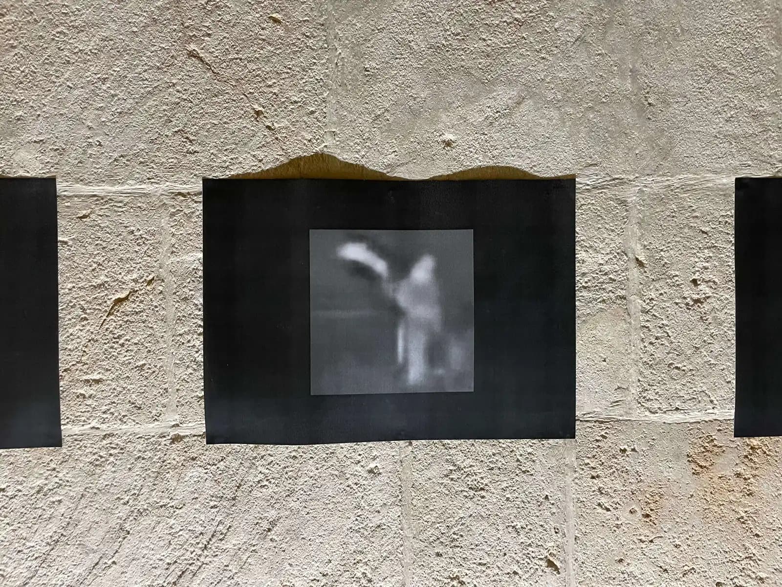 Small screen showing a blurred monochrome image on a textured wall